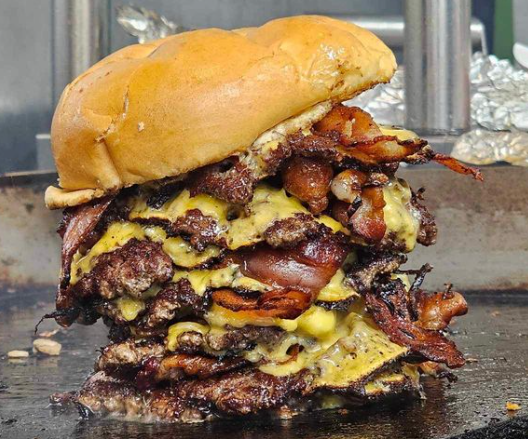 The Shakin Smash Meal Challenge — 4 patties stacked high with bacon, nacho cheese, and all the fixings